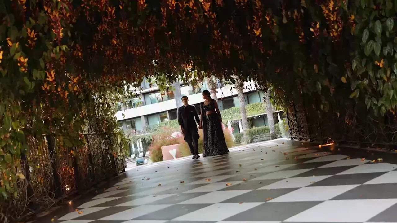 A couple walking hand in hand under a leafy canopy at Savoy Palace, wedding film by VIP Weddings Films